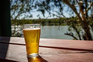 rafraîchissant Bière par le rivière photo