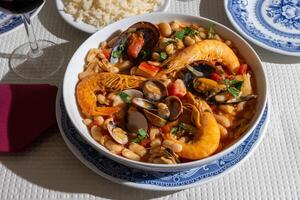 une traditionnel Alentejo restaurant sert une vibrant Fruit de mer feijoada. cette plat Caractéristiques crevettes, fruits de mer, et des haricots dans une rustique argile pot, offre une copieux et authentique Portugais expérience. photo