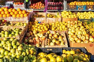 tachkent, Ouzbékistan - janvier 30 2023 fruit stalle dans le marché, illuminé par le Soleil. des oranges, Ananas, citrons et pommes. photo