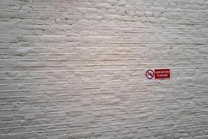 blanc brique mur avec signe dans néerlandais non Vélos à être garé photo
