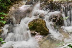 Montagne courant dans le forêt - longue exposition et écoulement l'eau photo