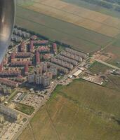 terre vue par le avion la fenêtre. des champs, routes, rivières de une des oiseaux œil voir. hublot. Regardez en dehors le fenêtre de une en volant avion. Haut vue de le sol photo