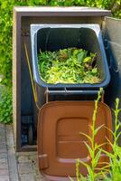 rempli biologique déchets des ordures pouvez dans le jardin photo