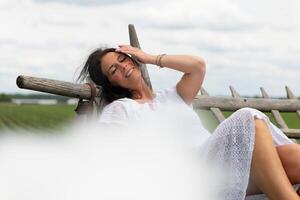 une femme dans une blanc robe avec une blanc fantaisie nuage dans le premier plan photo