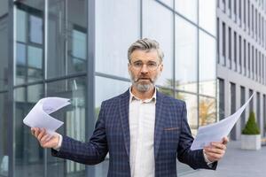 sur de soi professionnel dans une bleu chemise faire des gestes avec un ouvert main pendant une affaires présentation dans une moderne Bureau paramètre. photo