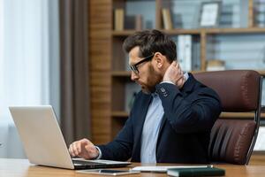 une mature homme dans une affaires costume les usages le téléphone, une homme d'affaire détient une téléphone intelligent dans le sien mains, les types messages et parcourt en ligne social les réseaux, une patron lit nouvelles, une souriant application utilisateur. photo