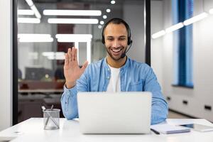 sur de soi professionnel homme séance à le sien bureau dans un Bureau environnement, engagé dans travail avec une casque. photo