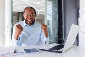 portrait de satisfait courtier investisseur, africain américain homme souriant et à la recherche à caméra, mature homme d'affaire en portant mains en haut célébrer succès, lieu de travail patron satisfait avec réussite résultats. photo