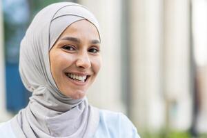 portrait de une de bonne humeur musulman femme portant une hijab en plein air, représentant culturel la diversité et Bonheur. photo