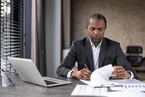 concentré Masculin exécutif dans une costume analyses formalités administratives. concept de direction, professionnalisme et concentration. photo