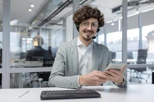 de bonne humeur Jeune homme d'affaire dans une casque à travail, affichage professionnalisme, compétence, et une positif émotif Etat dans une brillant Bureau environnement. photo