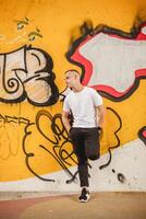 une homme des stands dans de face de une mur couvert dans graffiti photo