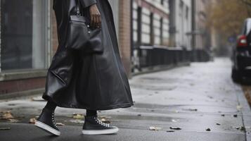 une lisse et moderne énorme cuir manteau jumelé avec une caleçon robe et baskets pour un inattendu et élégant combinaison photo