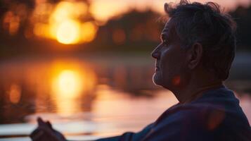 une paisible Lac à le coucher du soleil ses surface réfléchi dans le mans serein expression comme il se concentre sur le sien respiration pendant une calmant yoga session photo