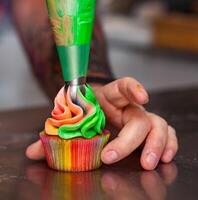 coloré petits gâteaux avec arc en ciel crème. photo