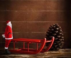 rouge traîneau avec pin cône et Père Noël claus photo