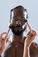 barbu gay homme appliquant maquillage avec brosses tenue par surgir artiste photo