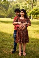 Indien couple posant pour maternité tirer pose pour accueillant Nouveau née bébé dans lodhi jardin dans delhi Inde, maternité photo tirer terminé par Parents pour accueillant leur enfant, pré bébé photo tirer