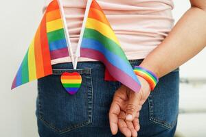 femme asiatique avec drapeau arc-en-ciel, droits des symboles lgbt et égalité des sexes, mois de la fierté lgbt en juin. photo