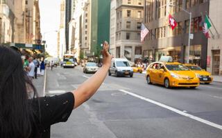 touristique appel une Jaune taxi dans Manhattan avec typique geste photo