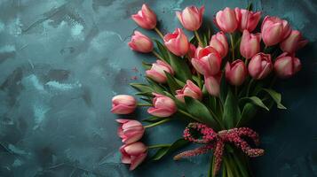 une bouquet de rose tulipes arrangé sur une texturé sarcelle arrière-plan, création une vibrant plat allonger parfait pour de la mère journée et printemps thèmes. photo