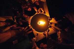 chiang mai - Thaïlande novembre 27, 2023. touristes joindre dans en portant lanternes à flotte dans le ciel pendant le loi Krathong yi peng Festival à prier pour bien fortune. photo