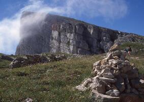 une la personne permanent sur une Roche dans de face de une Montagne photo