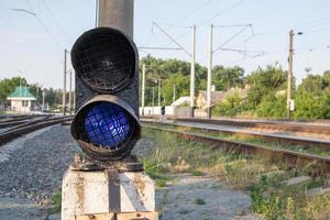 signal de chemin de fer avec lumière bleue avec une jonction de chemin de fer. feu de circulation bleu du train interdisant la circulation. jonction ferroviaire. industrie lourde. les chemins de fer. le feu de circulation sur la voie ferrée est allumé en bleu. photo