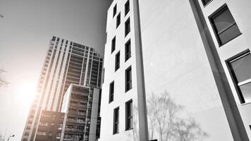 fragment de le bâtiments façade avec les fenêtres et balcons. moderne appartement bâtiments sur une ensoleillé journée. façade de une moderne Résidentiel bâtiment. noir et blanche. photo