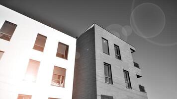 fragment de le bâtiments façade avec les fenêtres et balcons. moderne appartement bâtiments sur une ensoleillé journée. façade de une moderne Résidentiel bâtiment. noir et blanche. photo