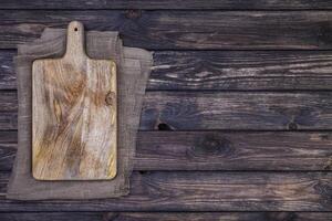 vieille planche à découper sur une table en bois sombre. vue de dessus. espace de copie photo