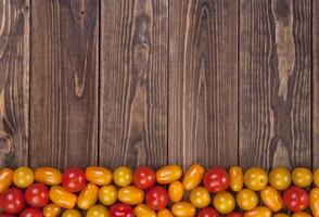 Cerise tomates sur en bois table arrière-plan, Haut vue photo