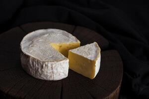 Camembert fromage sur noir en bois arrière-plan, avec copie espace. peu profond profondeur de champ photo