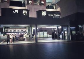 Kyoto, Japon sur octobre 2, 2023. gens en marchant dans et en dehors de Kyoto gare. le bâtiment est très majestueux et futuriste, dans de face de il est le Kyoto la tour. matin, après-midi, nuit. photo