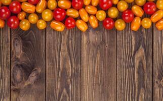 Cerise tomates sur en bois table arrière-plan, Haut vue photo