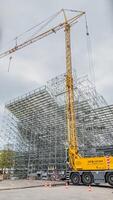 Jaune mobile grue à une construction site avec échafaudage, Paris, France, avril 14ème, 2024, représentant Urbain développement et ingénierie photo