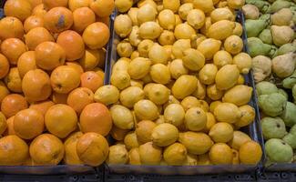 assortiment de Frais des fruits arrangé dans le épicerie boutique sur le comptoir. des oranges, citrons des poires, pommes sur nourriture marché étagère. variété de des fruits vendu dans le magasin. côté voir. sélectif se concentrer. photo