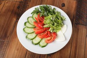 légume mélanger salade, concombre, tomate, persil et fromage photo