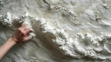 une qualifié main appliquant couches de texturé plâtre à une mur création une dynamique et tridimensionnel effet cette captures le œil photo