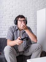 jeune homme jouant à des jeux vidéo à la maison mangeant du pop-corn photo