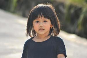 une petite fille s'amuse et court. un sourire sincère sur le visage d'une petite fille malaise. photo