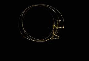 effet de lumière élégant en spirale rougeoyante de traînée de lumière d'or de cercle abstrait sur un noir. photo