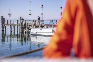 sirmione Italie 15 février 2023 une paisible et pittoresque vue de sirmione s Marina avec coloré bateaux amarré à le jetée ensemble contre une magnifique Naturel paysage photo