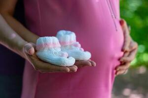 Enceinte femme sa partenaire en portant chaussons Contexte leur ventre concept grossesse maternité préparation attente photo