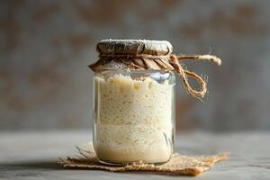 levain entrée dans une verre pot sur pente arrière-plan, concentrer sur le processus de pain fabrication photo