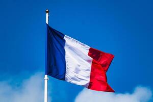 français tricolore drapeau flottant avec fort vent et bleu ciel photo