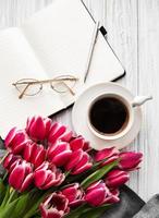 cahier, tasse de café et tulipes roses photo