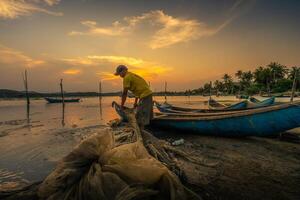 traditionnel les pêcheurs et bateaux dans o prêt lagune pendant coucher de soleil, phu yen province, vietnam. Voyage et paysage concept photo