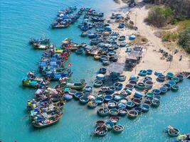 aérien vue de loc un pêche village, vung tau ville. une pêche Port avec tsunami protection béton blocs. paysage urbain et traditionnel bateaux dans le mer. photo