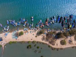 aérien vue de loc un pêche village, vung tau ville. une pêche Port avec tsunami protection béton blocs. paysage urbain et traditionnel bateaux dans le mer. photo